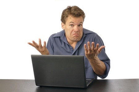 10471559 - puzzled man at computer shrugs shoulders and expresses lack of knowledge